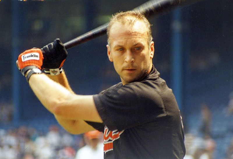 American professional baseball player Cal Ripken practices his swing before a game at Tiger Stadium in Detroit, Michigan, in 1993; by Rick Dikeman.