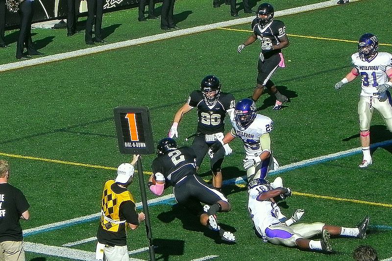 English:   Lindenwood University quarterback, David Ortega dives toward the goal line in a game against Kansas Wesleyan.